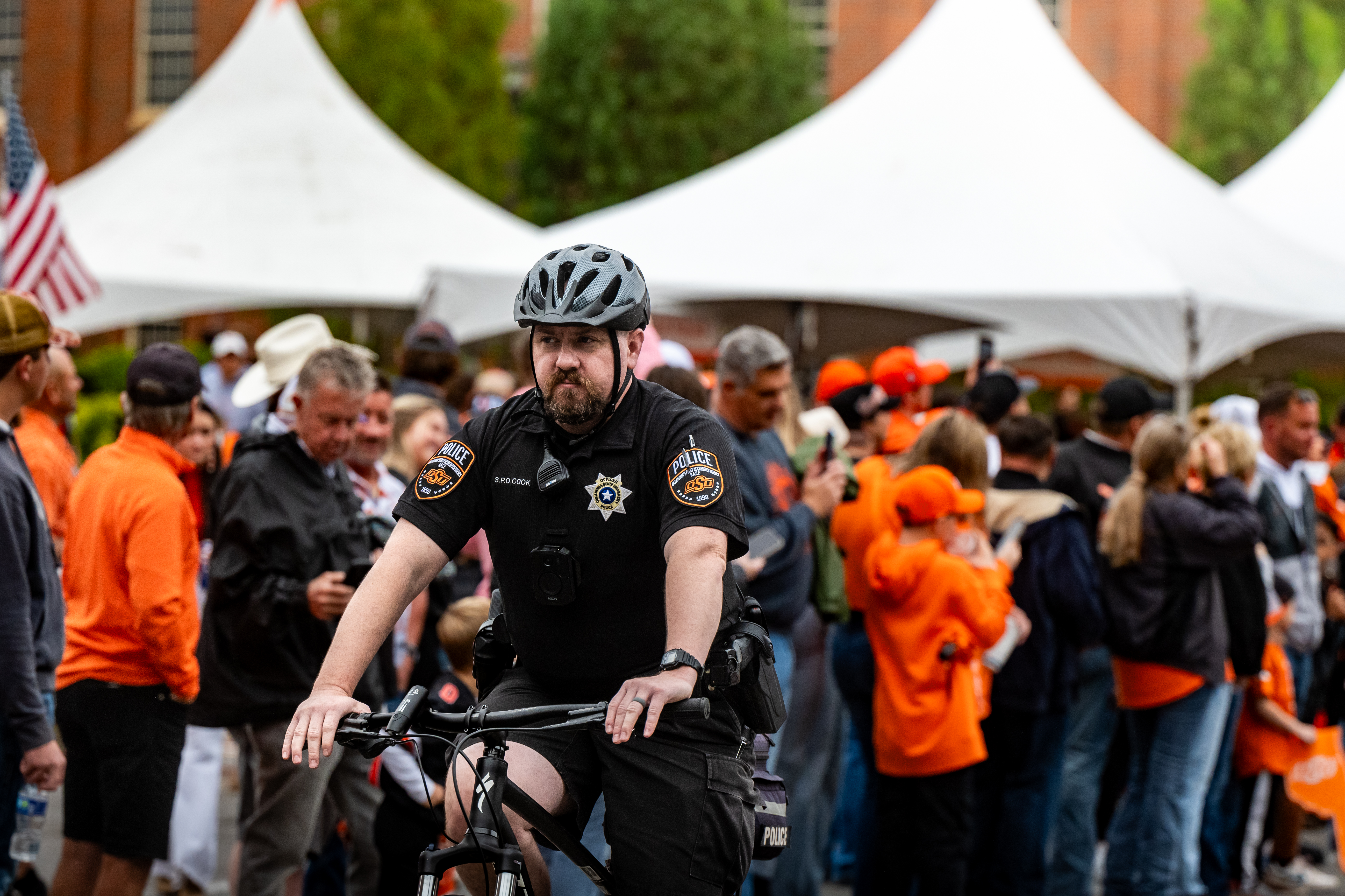 Officer riding a bike through a crowd while on patrol. 